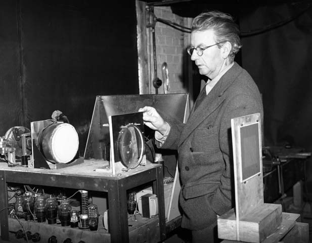 Baird Demonstrating - 17th December 1942:  Scottish electrical engineer and television pioneer John Logie Baird (1888 - 1946) giving a demonstration in his laboratory of his latest advance in colour television.  Baird was born in Helensburgh and studied at Glasgow University. Baird worked as an engineer at Clyde Valley Electric Power Company but had to retire due to ill health. He used his time to conduct experimental research into the transmission of images and gave a successful public display of his television system in London on 27th January 1926. In 1929 his mechanically scanned system was adopted by the BBC and he provided an improved system five years later. Baird also helped pioneer colour television and stereophonic sound.  (Photo by Topical Press Agency/Getty Images)