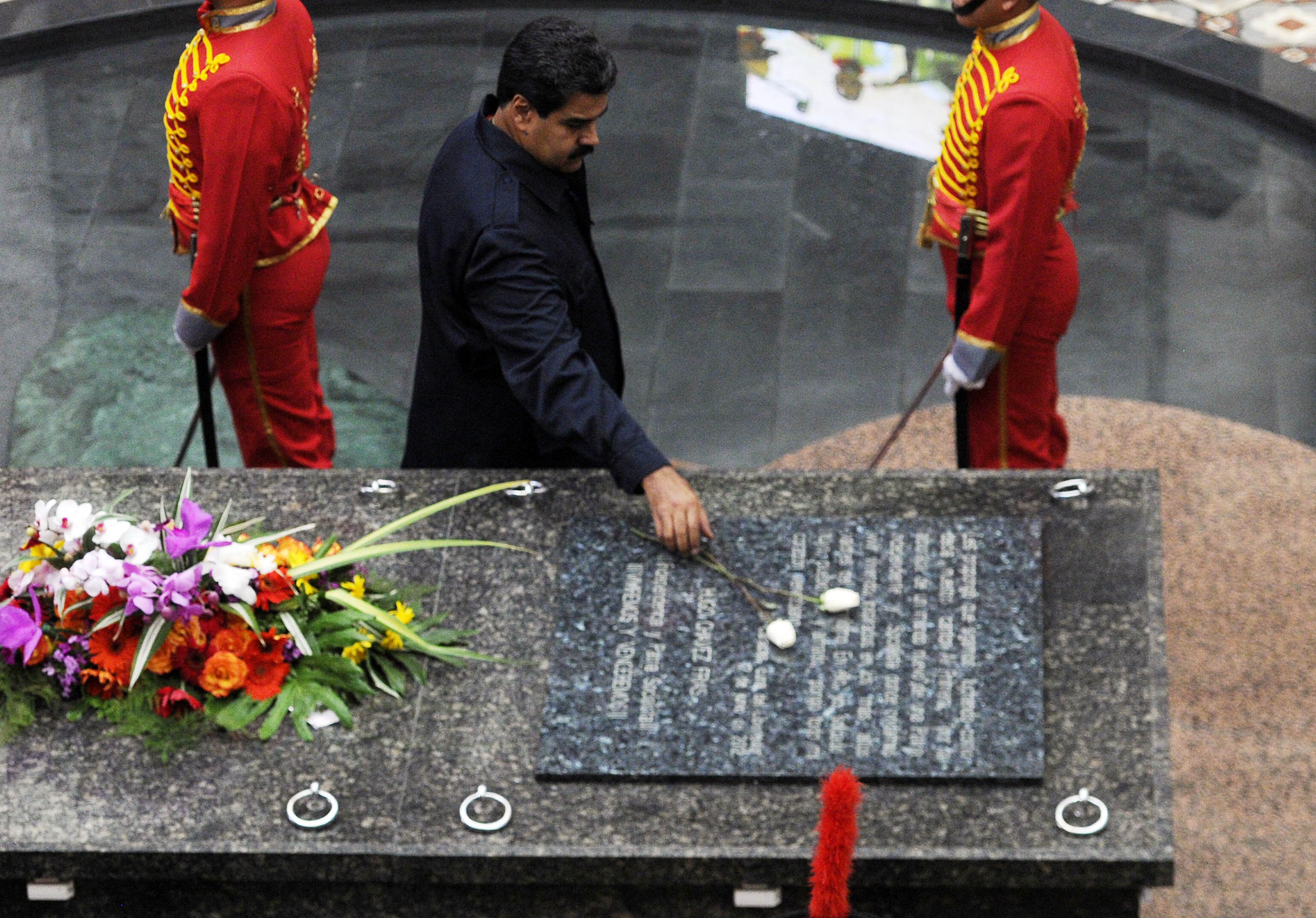 Chavez Grave - TOPSHOTS  Venezuelan President Nicolas Maduro places a rose atop the tomb of the late President Hugo Chavez during a ceremony within commemorations for his' death first anniversary, at the Cuartel de la Montana in Caracas on March 5, 2014. Venezuela marked the anniversary of Chavez's death with a blend of solemn ceremonies, clashes and a break in relations with Panama over protests dogging his successor's presidency.   AFP PHOTO/Leo RAMIREZ
